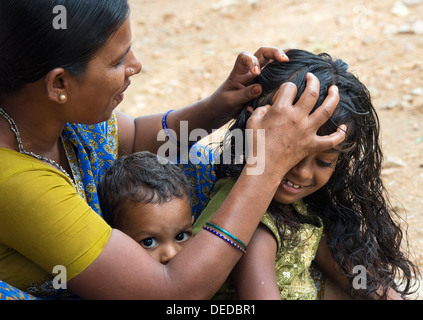 Indian mother nitpicking young girls head in a rural indian village. Andhra Pradesh, India Stock Photo