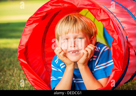 Cute Young Boy Playing Outside in Colorful Tunnel Stock Photo