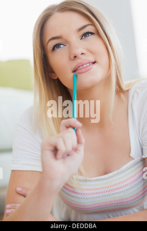 Young woman holding pencil in her mouth Stock Photo - Alamy