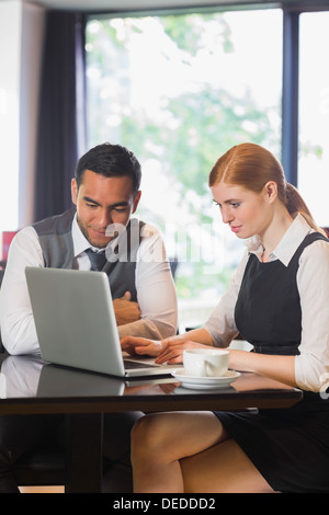 Smiling business team working together in a cafe Stock Photo