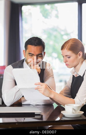 Serious business partners working together in a cafe Stock Photo
