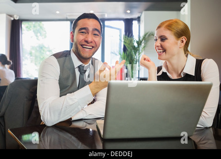 Laughing business people working on laptop Stock Photo