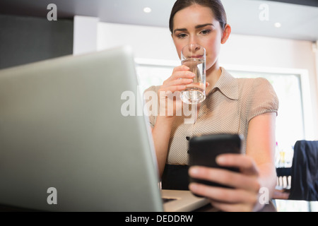 Businesswoman using phone in a cafe Stock Photo
