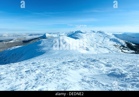 Sunny winter mountain landscape with low-hanging clouds and snowy ridge. (Chornohora , Carpathian, Ukraine). Stock Photo