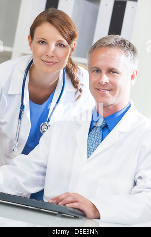 Male & female medical doctors using computer in a hospital office Stock Photo