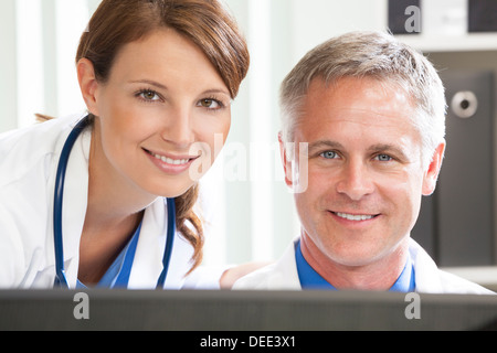 Male & female doctors using computer in a hospital office Stock Photo