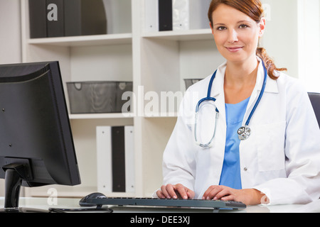 Woman female medical doctor using computer in her hospital office Stock Photo