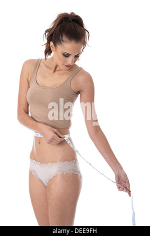 Model Released. Attractive Young Woman Measuring Her Waist Stock Photo