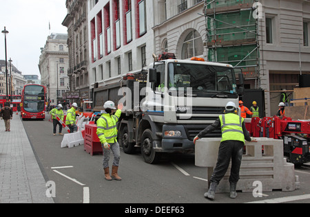 A lorry is maneuvered into place as roadworks cause disruption to traffic and pedestrians on London's Piccadilly Stock Photo