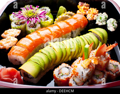 Different sushi rolls on a black plate. Stock Photo