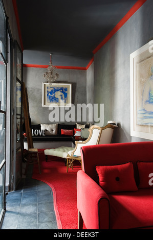 Red velvet and white cotton fabrics in living room of Marrakesh medina home with artwork by Paul Jacquette Stock Photo