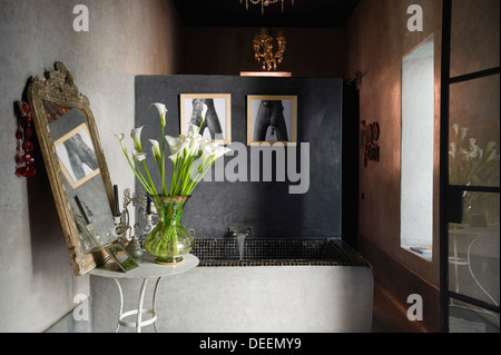 Concrete bath lined with small black ceramic tiles and partition wall in Moroccan home Stock Photo