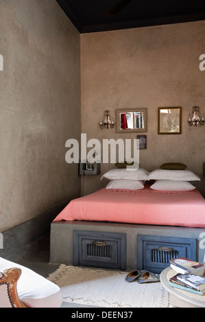 Mirrors above bed with storage compartments in Moroccan home Stock Photo