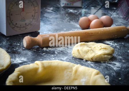 Rolling pin, scales, eggs and dough for baking a pie in a kitchen Stock Photo