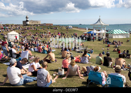 Crowd gathering around Southsea bandstand to watch a live performance by a local band. Southsea Castle in background. Hampshire, England UK Europe