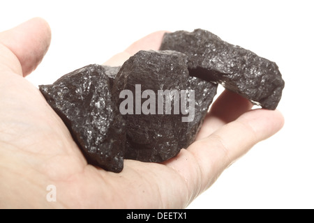 Coal lump carbon nugget in male hand isolated on white. Power and energy source. Stock Photo