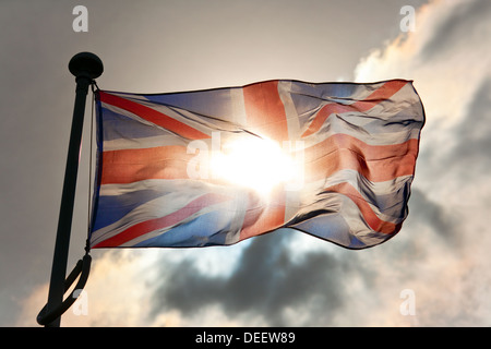 Union Jack flag flying, backlit by the sun, UK Stock Photo