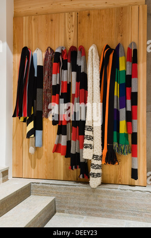 Swiss boot room with a collection of striped scarves representing various local club colours Stock Photo