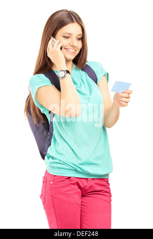 Female student with a school bag talking on a cell phone and holding a credit card Stock Photo