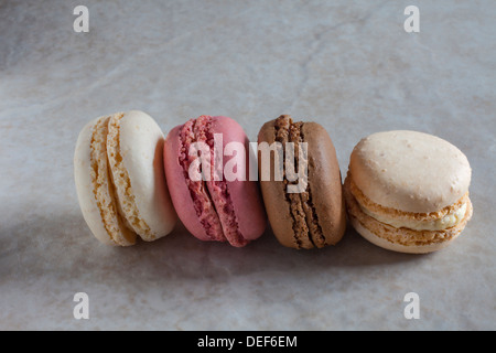 Four French-style macaroons on a marble-style background. Stock Photo