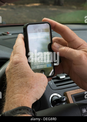 Male Hands Text Messaging While Driving Stock Photo