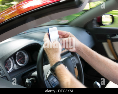 Male Hands Text Messaging While Driving Stock Photo