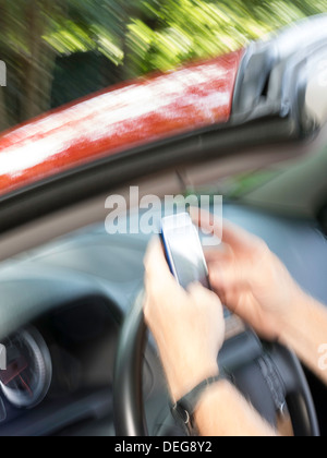 Male Hands Text Messaging While Driving Stock Photo