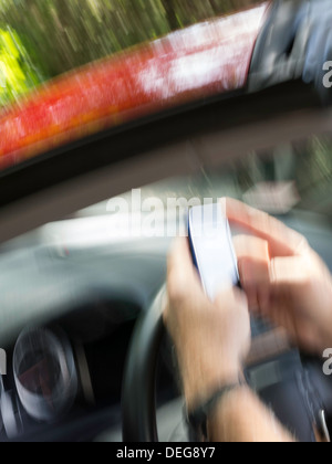 Male Hands Text Messaging While Driving Stock Photo