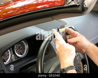 Male Hands Text Messaging While Driving Stock Photo