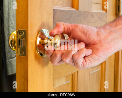 Mature Man's Hand Turning Door Knob Stock Photo