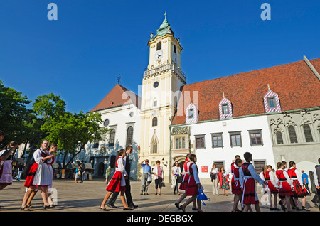 Children in traditional costume in the main square, Old Town Hall Municipal Museum dating from 1421, Bratislava, Slovakia Stock Photo