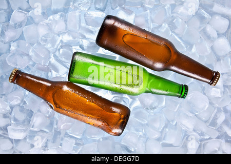 Three bottles of beer cooling on ice. Stock Photo