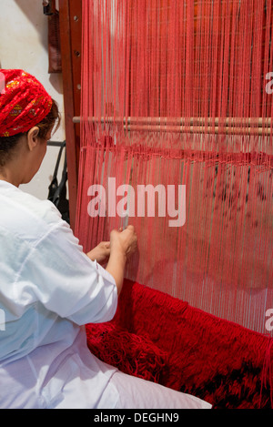 woman in Morocco is weaving a carpet Stock Photo