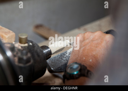 Craftsman hand working on the lathe producing a piece of furniture Stock Photo