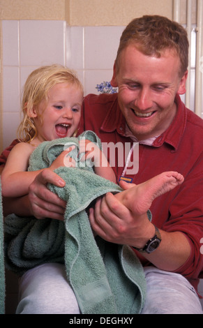 father drying his daughter with towel after a bath