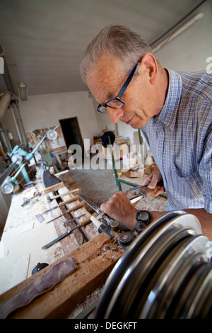 Craftsman working wood on the lathe inside his laboratory Stock Photo