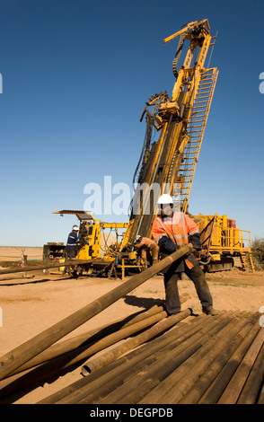 Rig operator pulling out core tube and making a new connection on RC diamond drill exploration rig, surface gold mine Mauritania Stock Photo