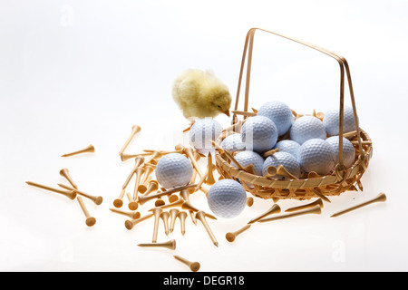 Fellow chick standing by a basket of golf balls and tees Stock Photo