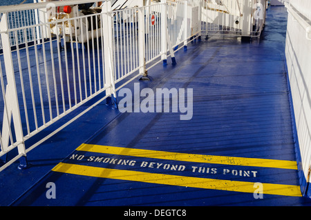 Sign on the floor of a deck on a ferry warning passengers that smoking is prohibited beyond this point. Stock Photo