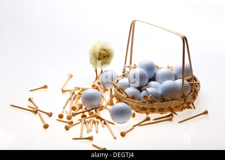 Fellow chick standing by a basket of golf balls and tees Stock Photo