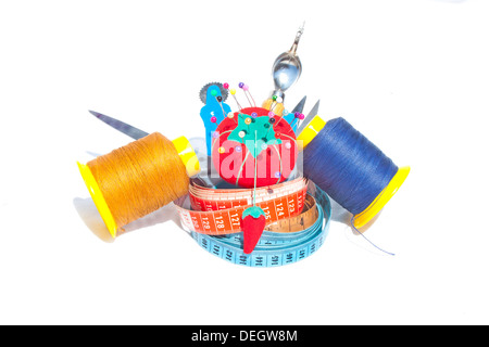 Three measuring tapes with reels of cotton and sewing accessories Stock Photo