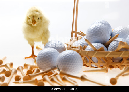 Fellow chick standing by a basket of golf balls and tees Stock Photo