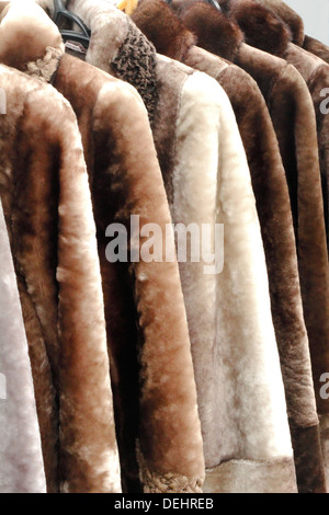 Beautiful warm womens coats made of natural fur hang in store for sale. Stock Photo