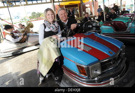 Munich, Germany. 19th Sep, 2013. Oktoberfest manager and economic consultant of Munich Dieter Reiter drives a bumper car with a woman wearing traditional costume during a press tour of Oktoberfest in Munich, Germany, 19 September 2013. Oktoberfest starts on 21 September 2013. Photo: TOBIAS HASE/dpa/Alamy Live News Stock Photo