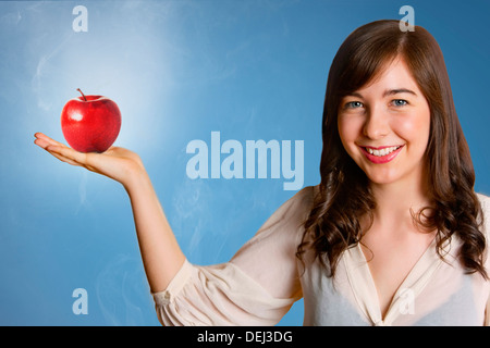 Beautiful young woman holding red apple Stock Photo