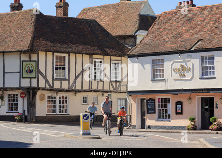 People cycling past 15th century Admiral Owen pub and 16th century Crispin Inn in historic Cinque Port town of Sandwich, Kent, England, UK, Britain Stock Photo