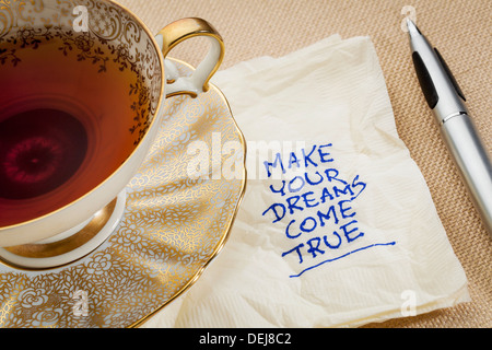 make your dreams come true - motivational slogan on a napkin with cup of tea Stock Photo