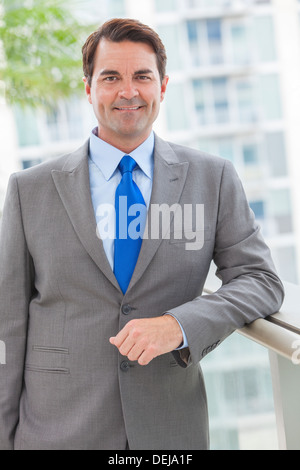 Successful businessman or man in a suit on roof of a corporate skyscraper office building Stock Photo