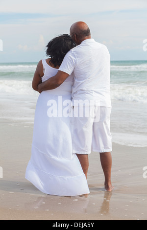 Rear view of senior African American man and woman couple on a deserted tropical beach Stock Photo