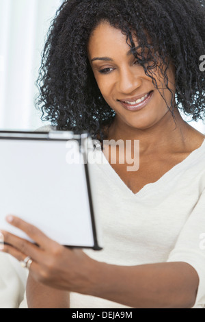 Beautiful smiling African American woman using her tablet computer. Stock Photo